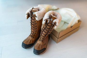 New winter hiking boots with open shoebox buying new shoes online shopping from home. Tall waterproof leather and sheepskin luxury footwear for winter.