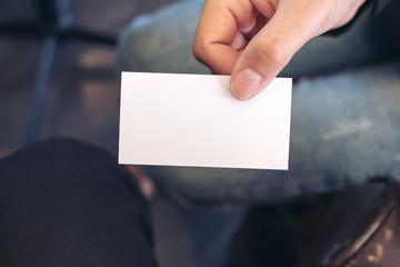 A woman holding and giving a blank empty business card to someone