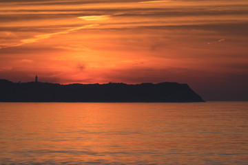 Fototapeta na wymiar Sonnenuntergang über Insel Hiddensee mit Leuchtturm Dornbusch und Ostsee