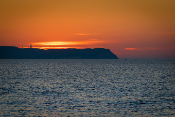 Naklejka premium Sonnenuntergang hinter Insel Hiddensee mit Leuchtturm Dornbusch