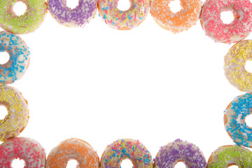 Flat lay view of many Frosted donuts with candy sprinkles arranged in a border frame isolated on white