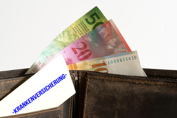 Eine Brieftasche mit Banknoten Schweizer Franken und die Krankenversicherung in der Schweiz