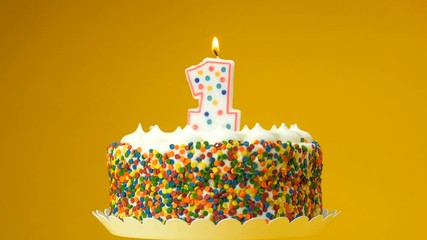 Decorated cake with number one candle on top