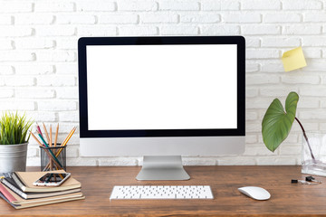 Fototapeta premium workspace with computer with blank white screen, and office supplies on a wooden desk