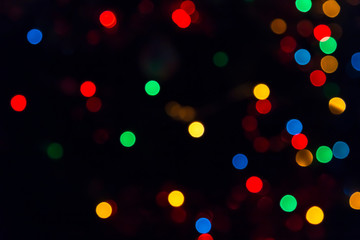 Obraz na płótnie Canvas Abstract festive New Year Christmas defocused background with bokeh multicolored effect on black background with copy space.