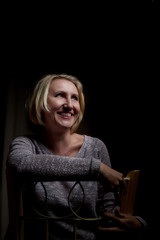 Portrait of a middle-aged woman in the room. Photography in the Studio. Photo shoot in a dark key