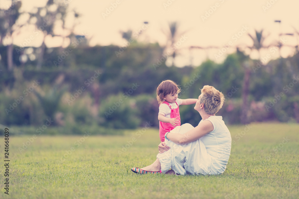 Wall mural mother and little daughter playing at backyard