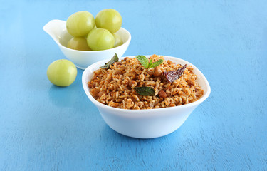 Puliyogare, a traditional and popular south Indian vegetarian rice dish that is spicy, with amla or Indian gooseberry as a main ingredient.
