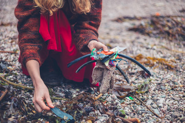 Obraz premium Woman cleaning up rubbish on the beach