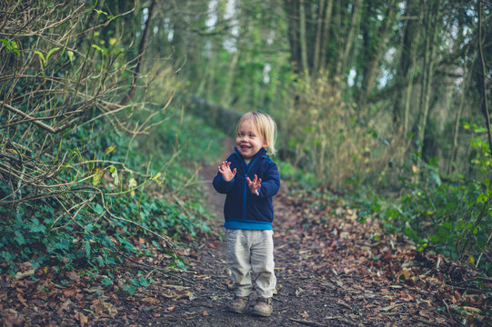 Little toddler standing on path in the woods