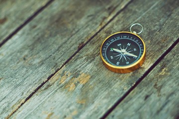 Compass on wooden background, vintage tone, journey planning concept, blank space, top view