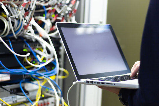 Administrator working in data center configure and check internet network on computer laptop ,Hands typing text on a laptop keyboard , Selective focus