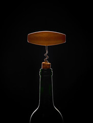 Silhouette of wine bottle with opener on the black background