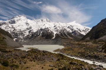 Hooker River emerging from Mueller lake. snow capped mountains and glaciers in the background. From the Hooker Valley Track, Aoraki/Mount Cook National Park New Zealand.