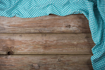 Blue checkered tablecloth on wooden table for background. Fabric texture. Wood texture. Copy area....