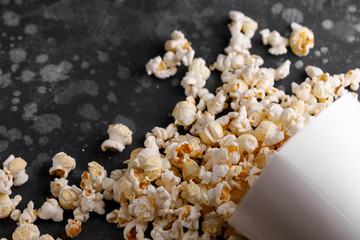 Snack for watching movies. Popcorn bucket upside down on a textural background.