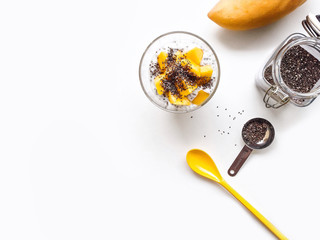 Mango yogurt with chia seeds for healthy breakfast on a white background, top view copy space