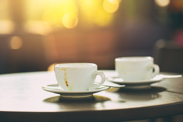 two coffee cups on wooden table in the morning cafe vintage tone.