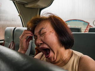 portrait Photo of Senior asian womam Yawn on the Bus when her vacation.