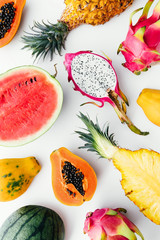 Flat lay tropical fruit layout made of dragon fruit, watermelon, papaya and pineapple. Creative...