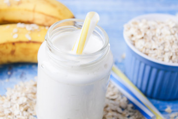 Banana smoothie with honey and oats on a wooden table.