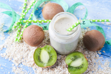 kiwi Banana smoothie with honey and oats on a wooden table.