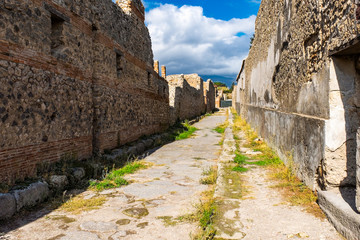 An ancient cobbled street in the ruins of Pompeii. Roman town destroyed by Vesuvius volcano.