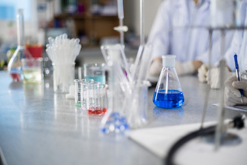 Chemistry laboratory glassware containing chemical liquid - Blue liquid glass on the table