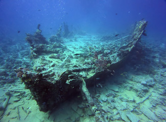 Big ship wreck boat underwater view. Diving picture with deep mood atmosphere. Beauty of sea oceans dark waters with wildlife fishes, corals and shells. Abstract landscape scenery, dive site objects