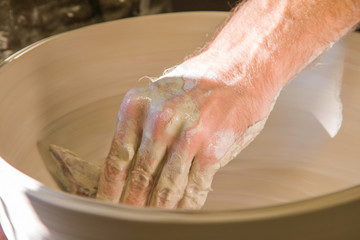 Artist potter in the workshop sculpting ceramic vase. Small artistic craftsmen business concept. 