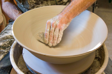 Artist potter in the workshop sculpting ceramic vase. Small artistic craftsmen business concept. 