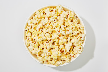 Full of popcorn in bowl on white background
