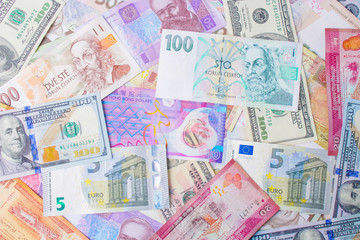 Close up on pile of many bank notes from various countries from around the world. U.S., German, Swiss, Canadian, Brazilian, Vietnamese, Mexican. Many countries represented in currency. 