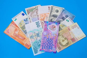 Close up on pile of many bank notes from various countries from around the world. U.S., German, Swiss, Canadian, Brazilian, Vietnamese, Mexican. Many countries represented in currency. 