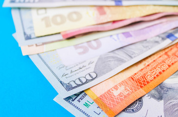 Close up on pile of many bank notes from various countries from around the world. U.S., German, Swiss, Canadian, Brazilian, Vietnamese, Mexican. Many countries represented in currency. 