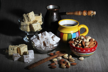 A mug of coffee and different oriental sweets: turkish delight, halva, almond and pistachio
