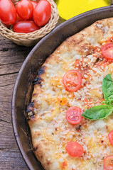 Closeup of homemade pizza on wooden background