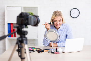 cheerful woman video blogger recording vlog video about make up