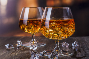 Two glasses of Cognac with ice cubes