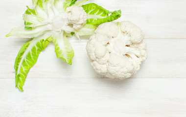 Fresh raw cauliflower on rustic white wooden background top view flat lay copy space. Cooking, healthy wholesome food, vegetable, diet concept.
