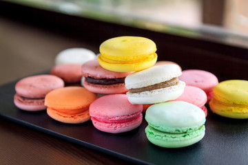 cookie macaroni  red yellow green and brown. filed on a wooden board and black tile