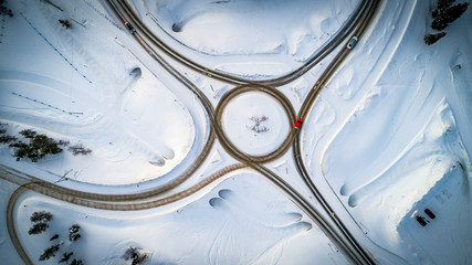 Aerial top view of country road junction in winter time, snow forest road, travel and transportation concept
