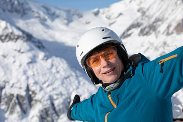 Fototapeta na wymiar Senior Skifahrerin mit Helm und Brille auf der Skipiste
