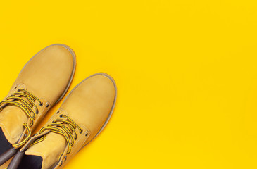 Fashionable concept. Yellow men's work boots from natural nubuck leather on bright yellow...