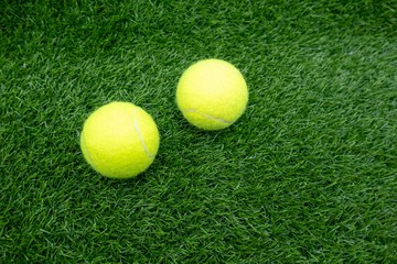 Two tennis balls are on green grassx