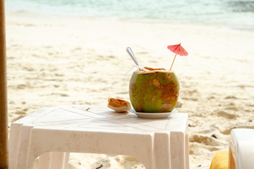 Coconut juice against blurred beach background