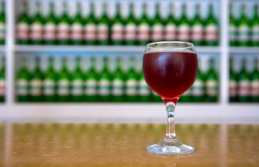 Cold wine in a glass on the background of bottles.