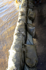Sandbags keep the water on one side of a temporary embankment.