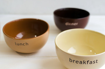 Set of bowls. Written breakfas, lunch, dinner on ceramic bowls. Menu concept