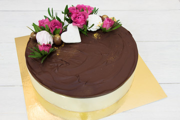 Birds milk Cake with fresh rose flowers. Milk souffle with dark chocolate glaze. Pigeon milk cake with souffle cream